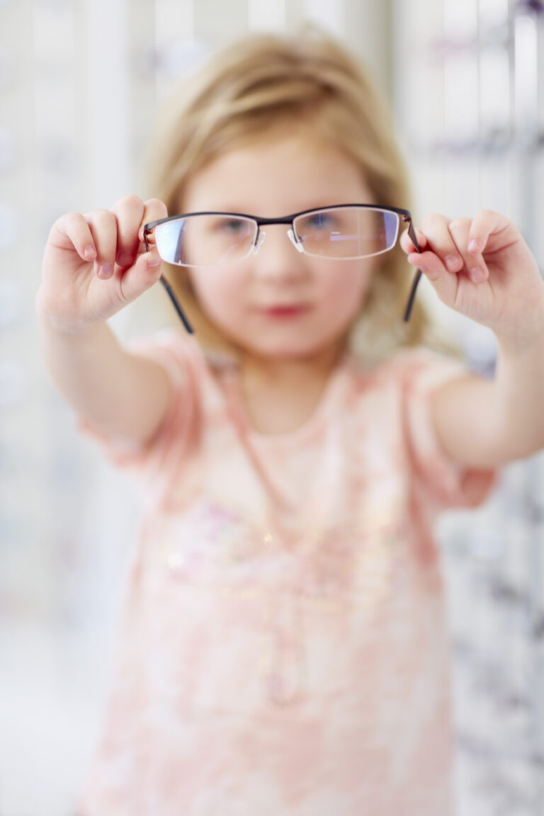 Girl at the optician holding glasses