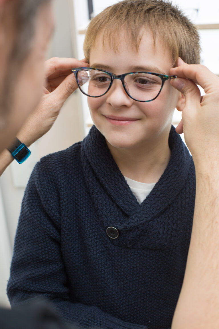 Cute young boy trying on glasses in an eyewear store